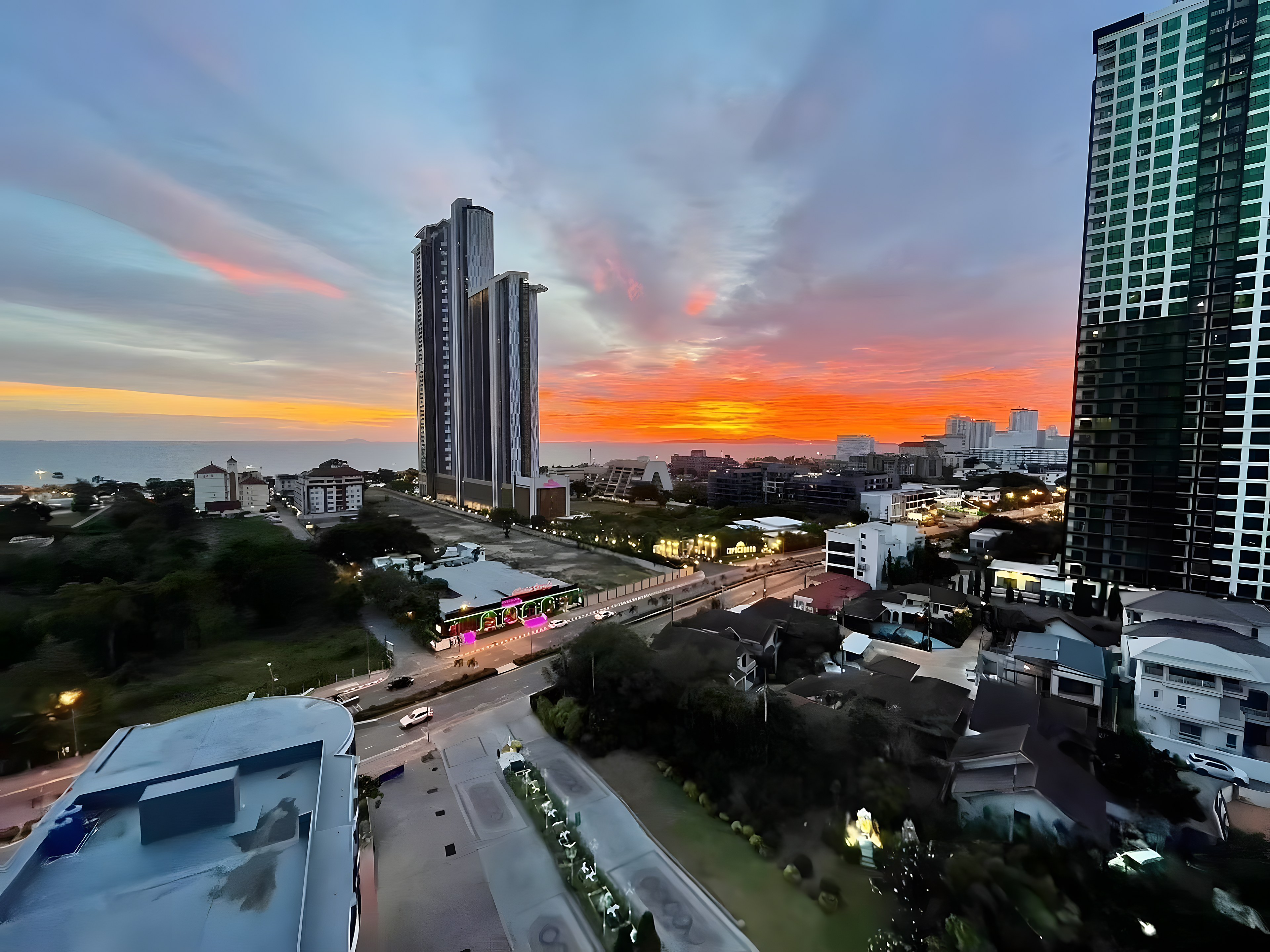 Twin towers of the Jomtien beachfront condominium at sunset over Pattaya bay